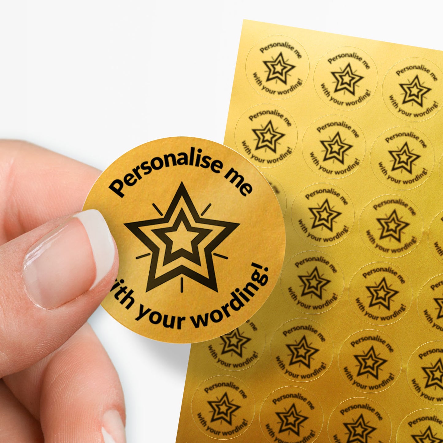Sheet of gold stickers with a black star in the middle and text. Single sticker held between finger and thumb