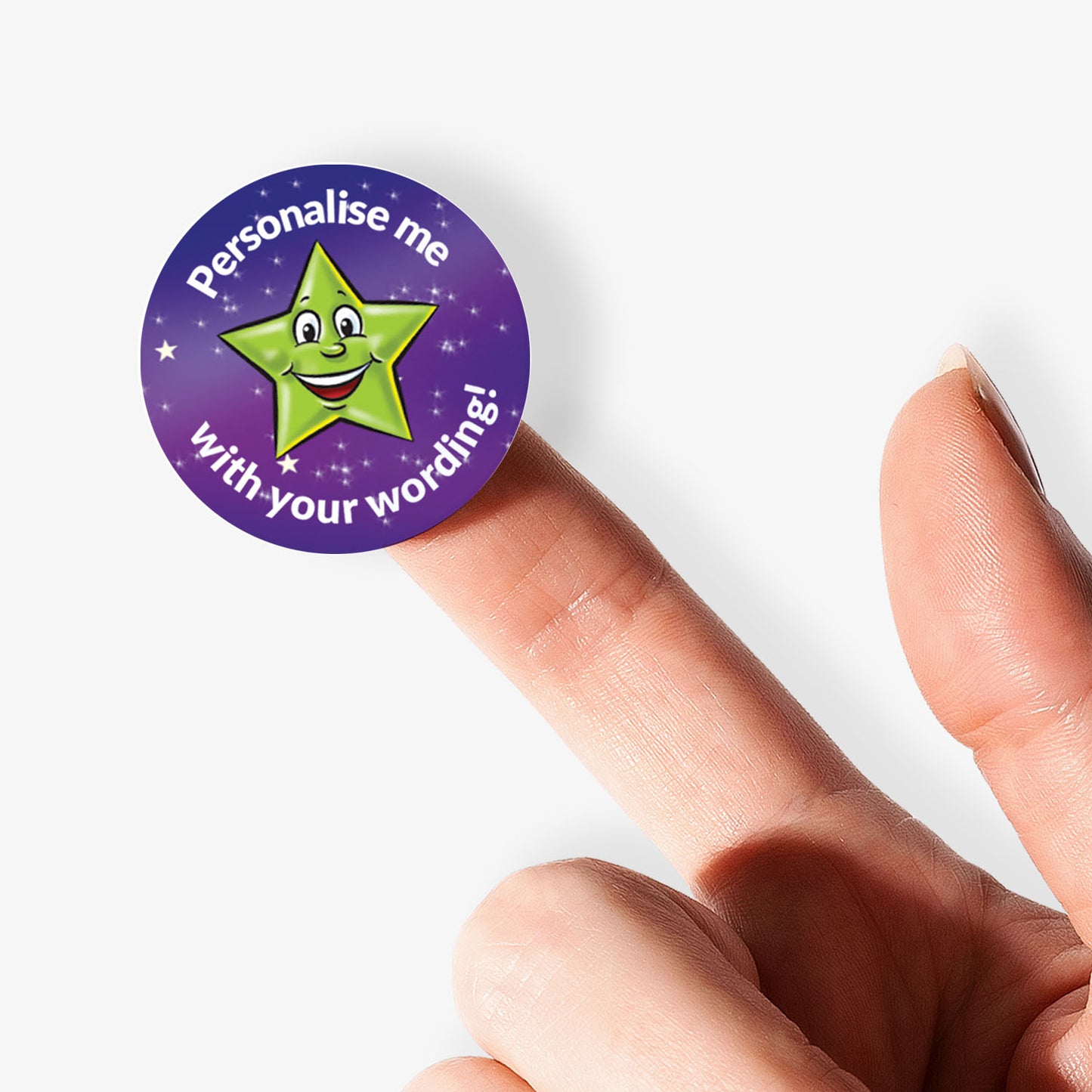 Round purple sticker with a green star and text on a finger against a white background