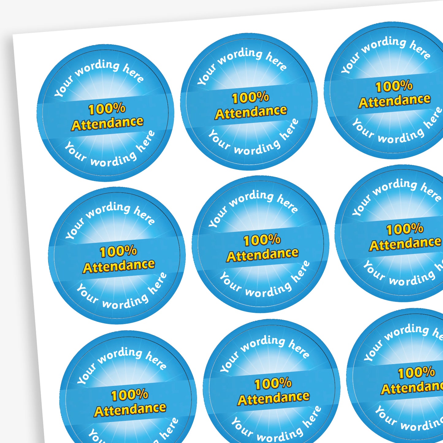 Sheet of 70 round, cyan stickers, each 25mm in diameter, featuring bold yellow text reading '100% Attendance' at the centre. Surrounding the central text is placeholder wording 'Your wording here' above and below, indicating customisable areas for personalised messages.
