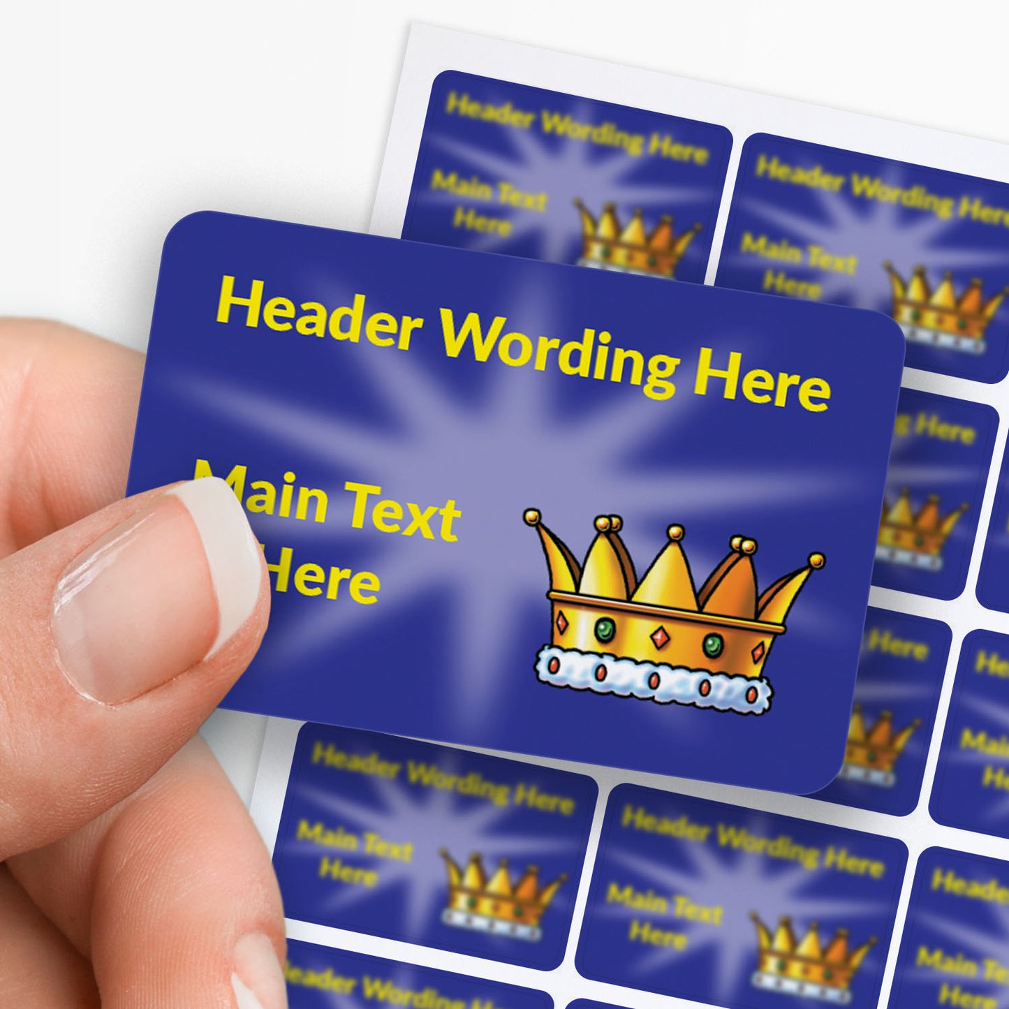 Blue stickers with yellow text and a crown icon held by a hand with sheet in the background