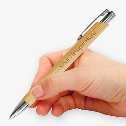Hand holding a personalised bamboo ballpoint pen, showing its comfortable shape, engraved design and silver-tone detailing.
