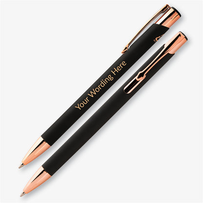 Two black personalised pens with rose gold detailing, showing the engraved wording and metal pocket clip.