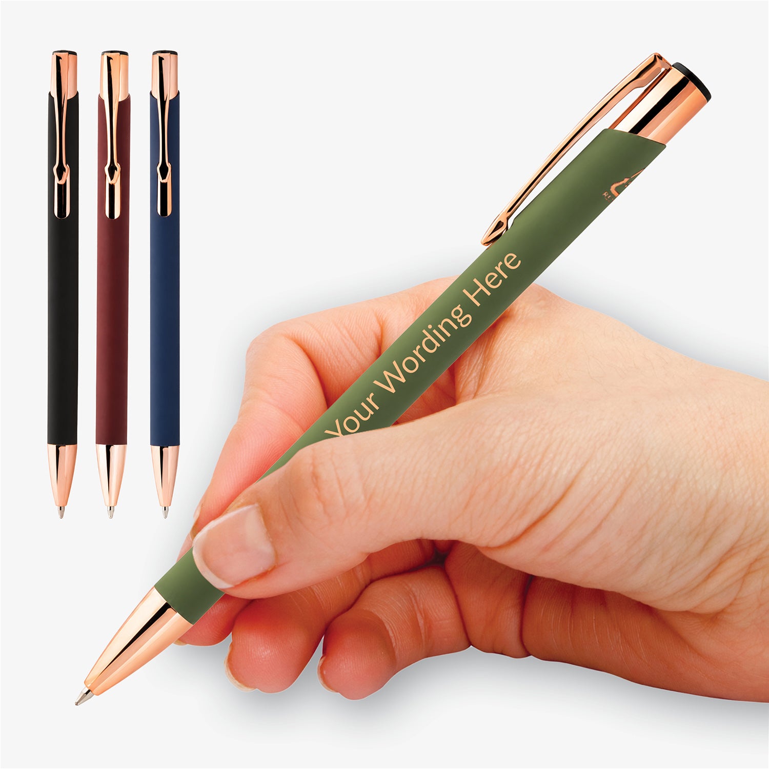 Personalised recycled aluminium pens in black, burgundy, navy and green with rose gold detailing, including a green pen held in the hand.