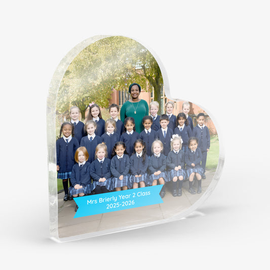 Acrylic heart-shaped photo plaque with a school class photo and teacher. Small blue banner with the text 'Mrs Brierly Year 2 Class 2025-2026'. Shown on a white background.