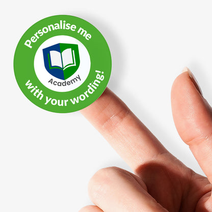 Hand holding a green sticker with 'Personalise me Academy' text on a white background