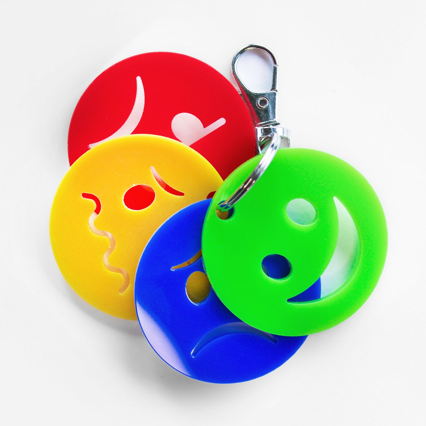 Keyring with four faces showing different emotions. Green happy face at the front.