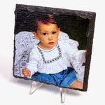 Slate photo plaque with a young child wearing a white blouse and blue shorts on a stand.