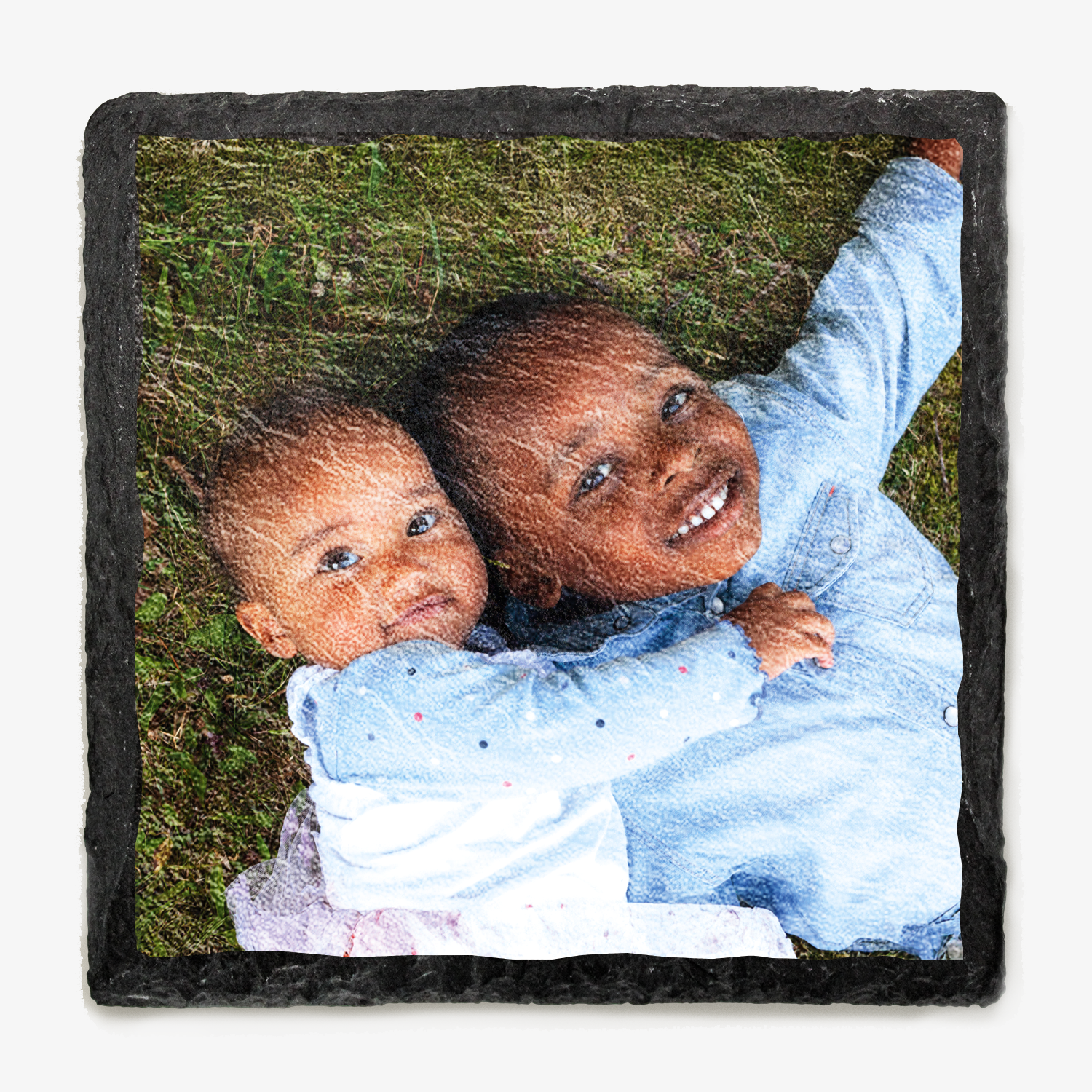 Photo of two children hugging on grass printed onto a slate coaster - natural finish.