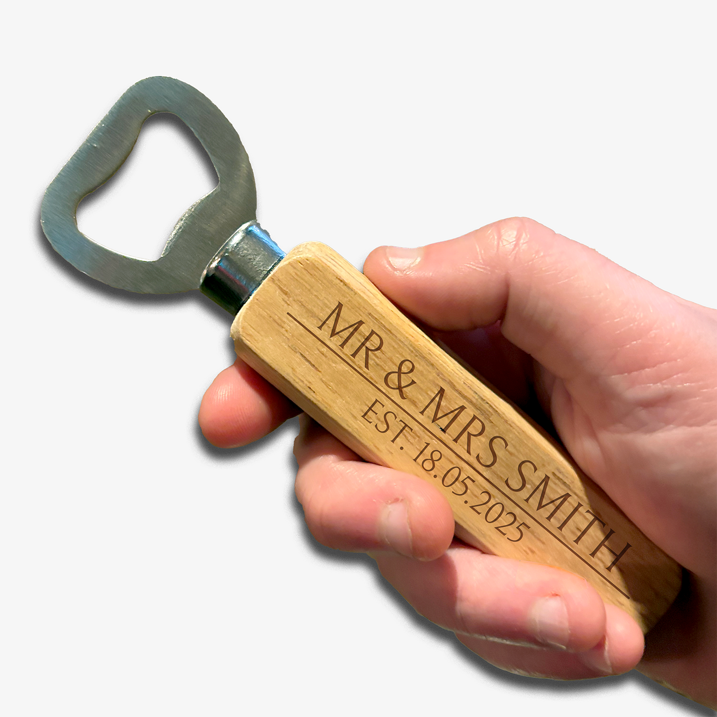 Hand holding bottle opener. Metal opener with wooden handle which has two rows of etched writing for you to personalised. Example text top: Mr & Mrs Smith, bottom: Est. 18.05.2025.