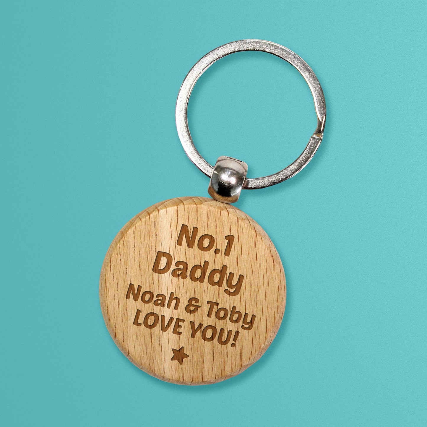 Circular wooden keyring with a metal ring, engraved with text for customisation saying 'No. 1 Daddy' and underneath 'Noah & Toby LOVE YOU!' with a star at the bottom.