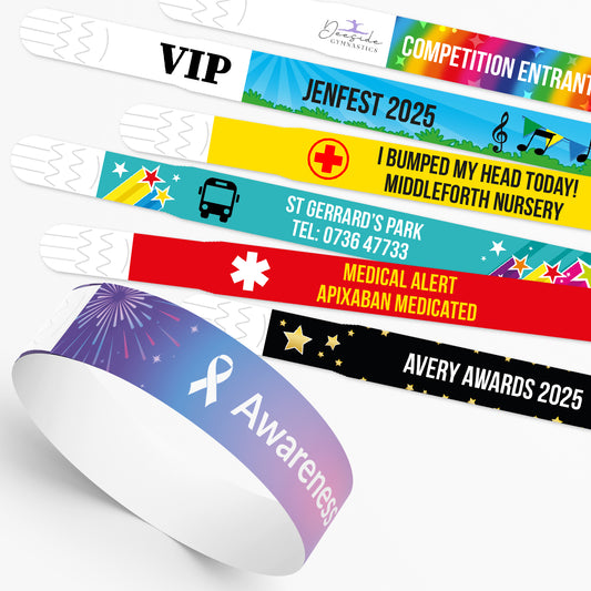 Customisable wristbands in various colourful designs, each displays placeholder text alongside an icon. Background themes include stars, galaxies, and rainbows. At the base of the image, there are additional icons such as a bus, VIP badge, ribbon, phone, and medical cross, suggesting design options for personalisation. 