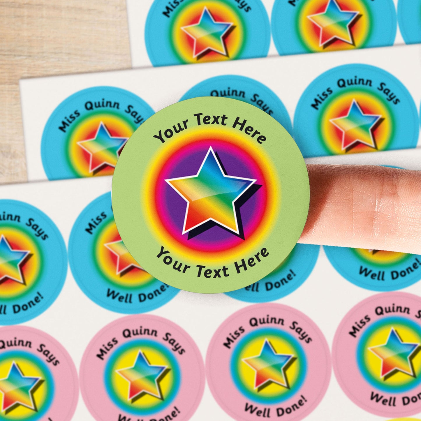 A close up image of a rainbow star on a sticker with a pastel green border.  Text around the star is customisable
