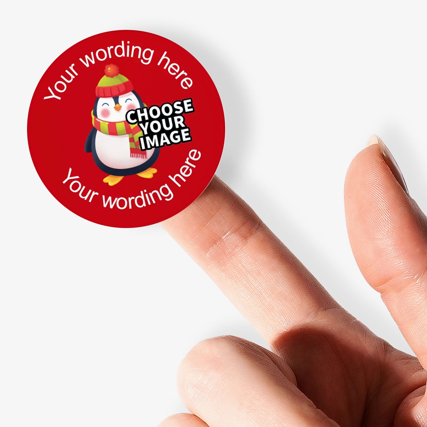 Round red sticker with penguin graphic and customizable text held by a hand