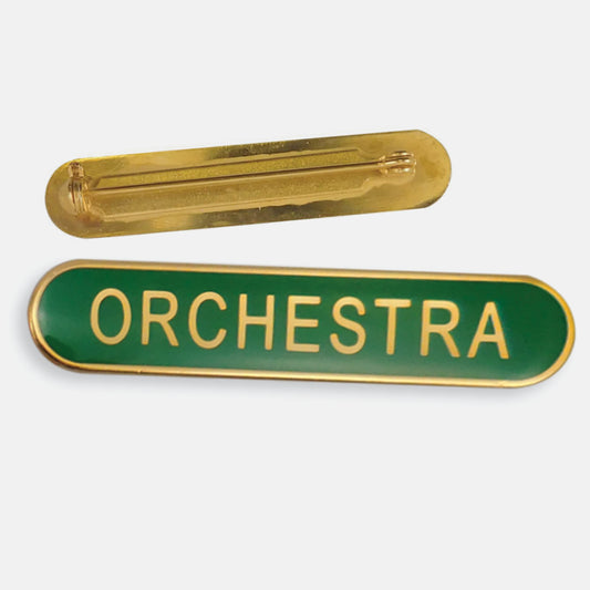Green enamel badge in a long oval shape with a gold trim and the word 'ORCHESTRA' central in gold capital letters. The reverse side shows a gold back with a pin fastening