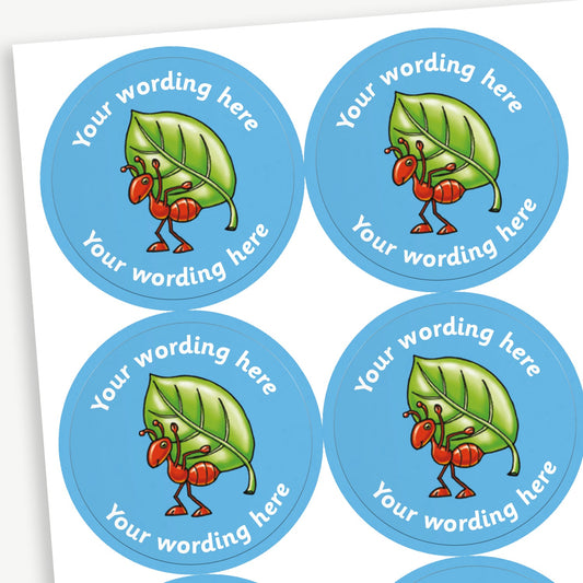 Sheet of round blue stickers featuring an ant carrying a leaf on it's back in the centre. Each sticker has placeholder text reading 'Your wording here' curved above and below the illustration. 
