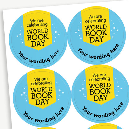 Sheet of round blue stickers celebrating World Book Day. Each sticker features a yellow pennant design with the text 'We are celebrating WORLD BOOK DAY' and has placeholder text 'Your wording here' curved along the bottom edge. Small stars are scattered around the badge for decoration.