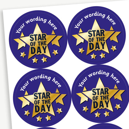 A sheet of round dark blue stickers, each featuring a large golden star with the text 'Star of the Day' in bold black letters with four smaller gold stars beneath and two behind. The top arc of each sticker has placeholder text 'Your wording here' for customisation.