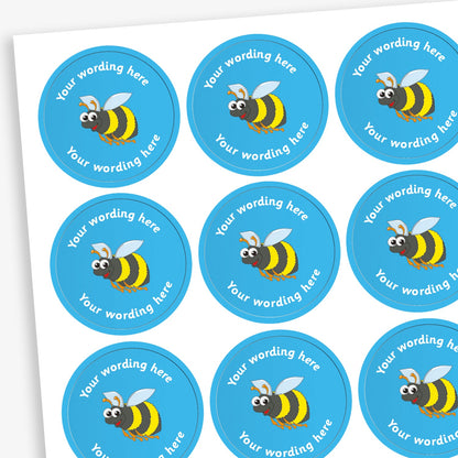A sheet of circular reward stickers featuring a blue background with a bumble bee in the centre. Each sticker includes the placeholder text 'Your wording here' curved along the top and bottom edges, indicating customisable space for personalised messages