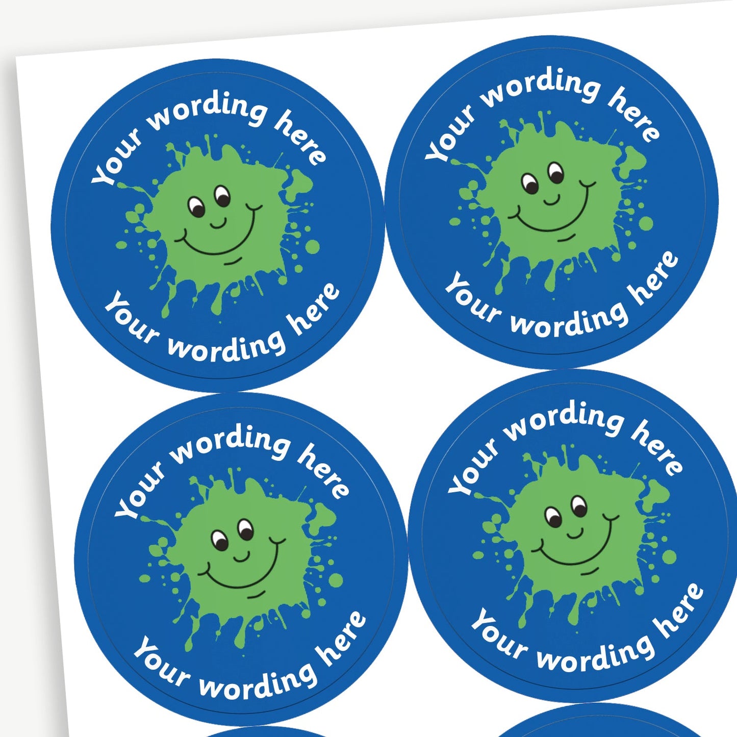A sheet of blue stickers featuring a central image of a green smiling ink blot.  Placeholder text 'Your wording here' is above and below the image.