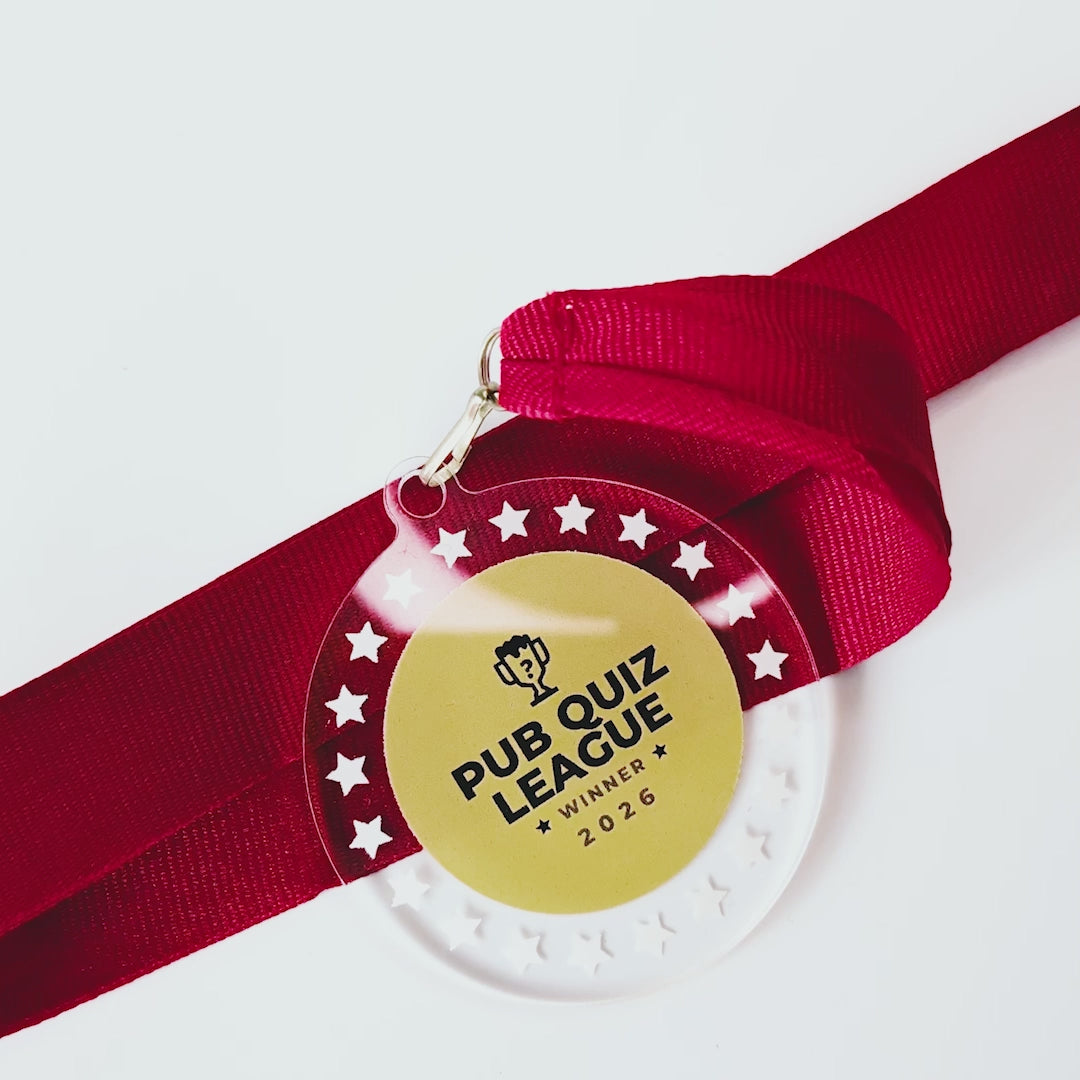 Video of a transparent acrylic medal with pub quiz league logo and red ribbon