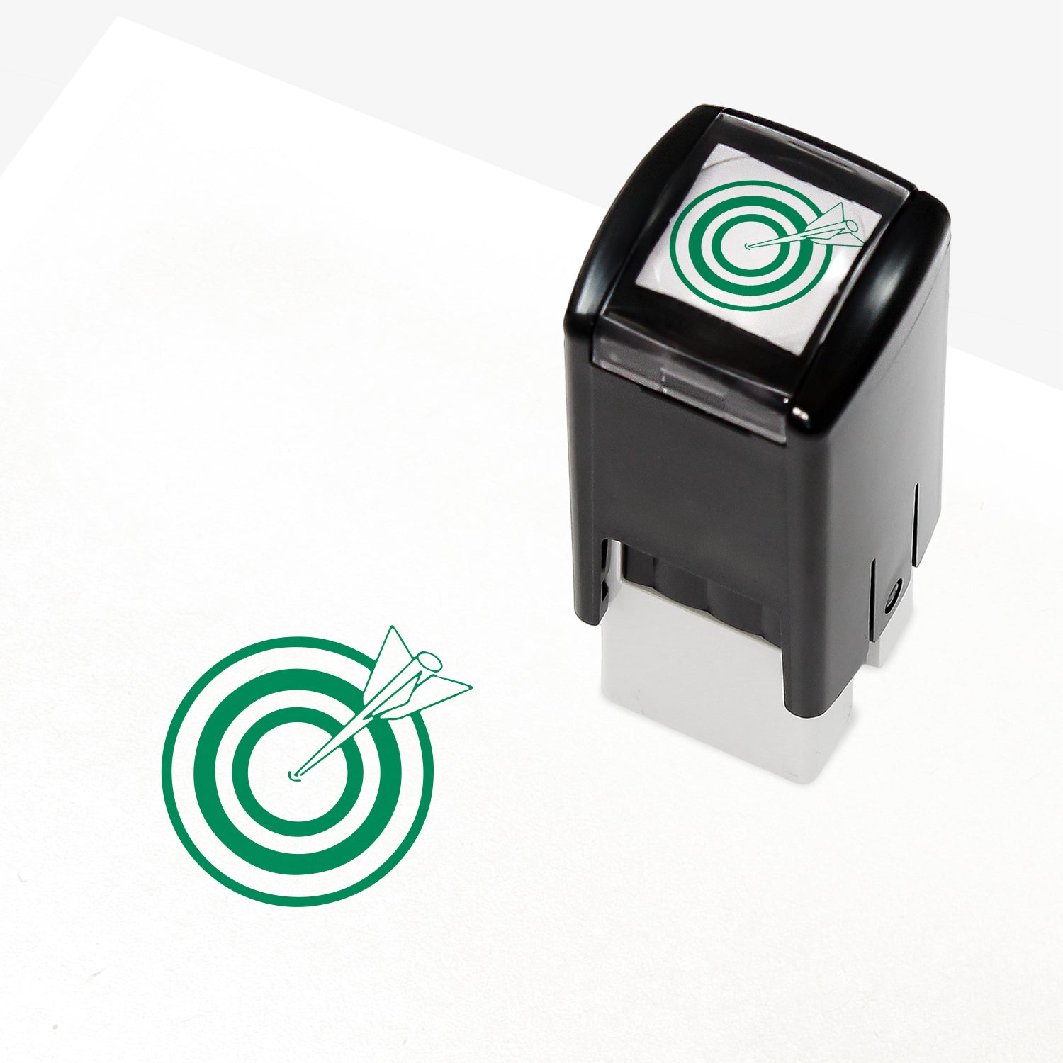 Target Stamper from Primary Teaching Services, featuring a compact black casing with a green bullseye and arrow design. The stamp imprint measures 10mm in diameter and is available in various ink colours, ideal for marking pupil achievements.