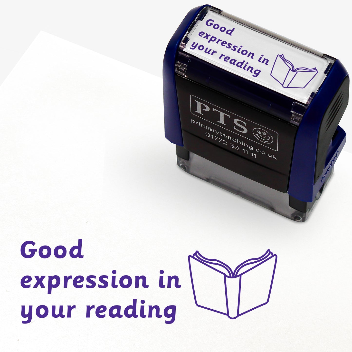 Rectangular self-inking stamper measuring 38mm by 15mm, featuring the phrase 'Good expression in your reading' in purple text alongside an open book icon; available in green or purple ink, ideal for providing feedback in pupils' reading records and homework diaries.