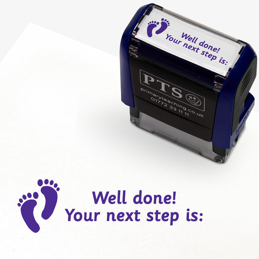 Rectangular self-inking stamper with purple ink, displaying a purple footprint icon alongside the text 'Well done! Your next step is:'; designed for marking and providing feedback in pupils' reading records and homework diaries.