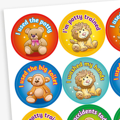 Sheet of round potty training reward stickers featuring cute cartoon teddy bears and lions. Each sticker includes a positive message such as 'I used the potty', 'I'm potty trained', 'I used the big toilet', and 'I washed my hands', displayed on bright coloured backgrounds like red, yellow, blue, and teal.